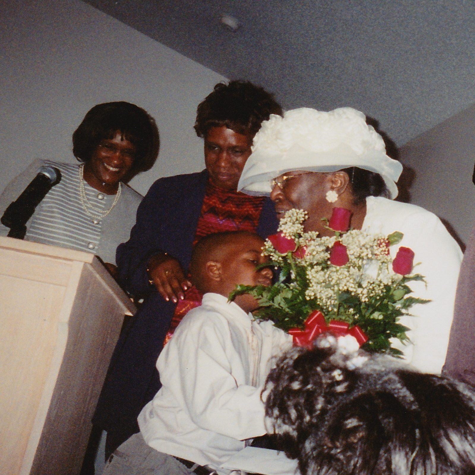 Annie Will Bell Gatlin in white, receiving a bouquet of roses from a young boy at church